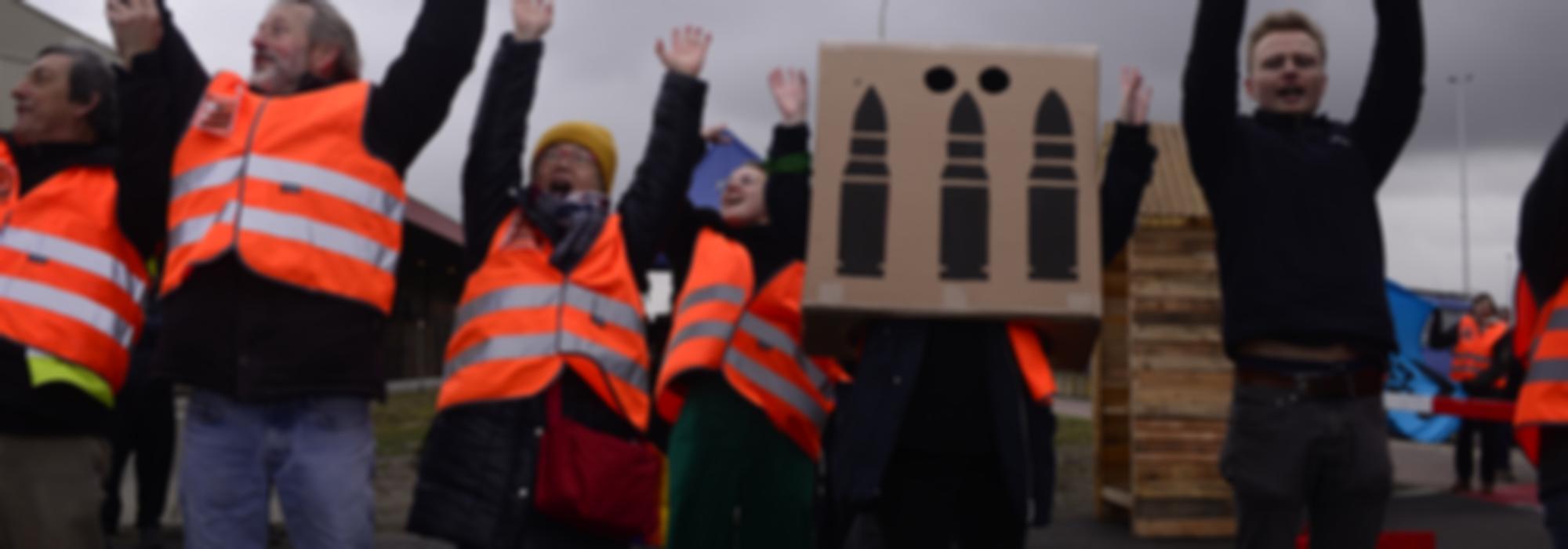 Vredesactivisten doen een mexican wave tijdens actie. 