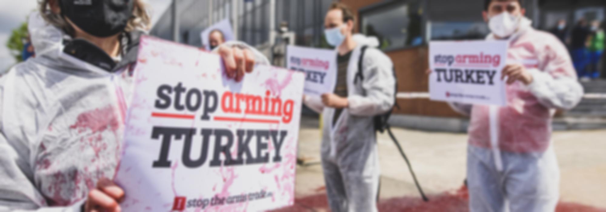 actievoerders bij wapenfabriek Sabca houden bordje "Stop Arming Turkey" vast